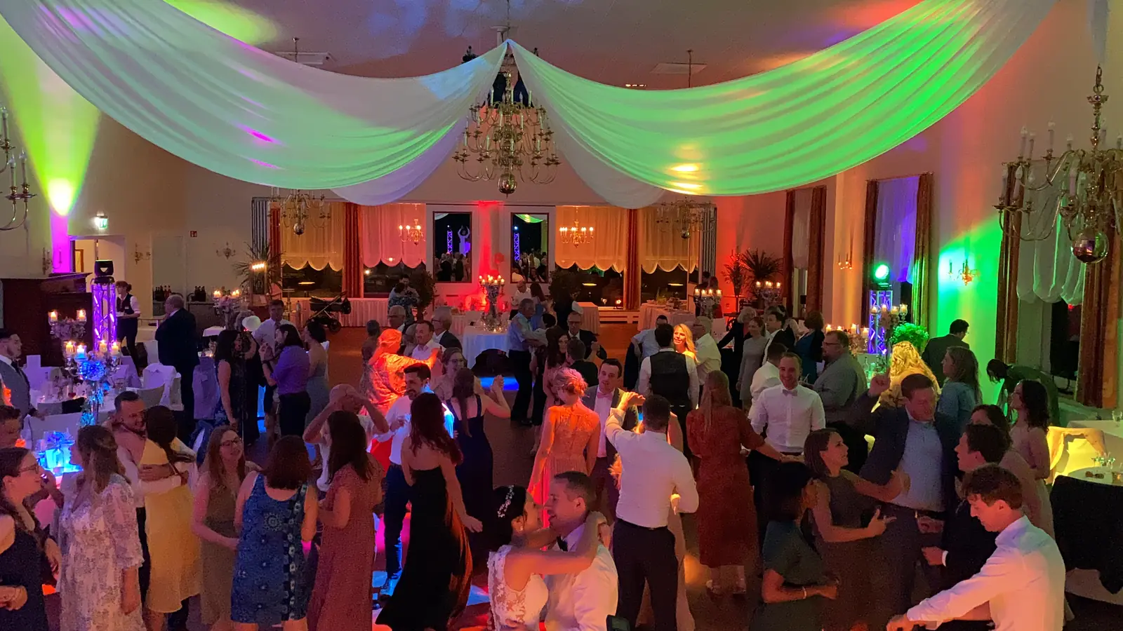 Tanzende Gäste unter buntem Partylicht