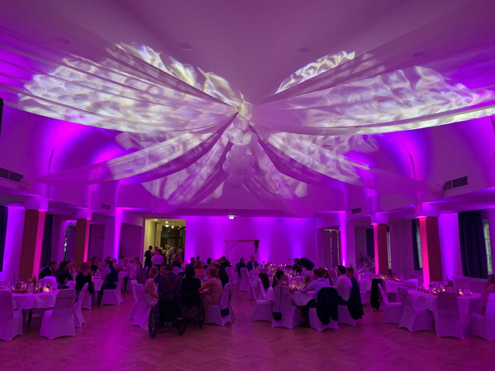 Hochzeitssaal mit Stoffbahnen und Lichtmustern an der Decke